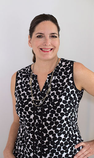 A lady wearing black dress, smiling at the camera