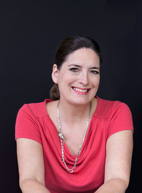 A lady wearing red dress, smiling at the camera