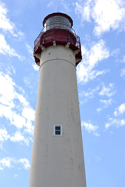 A long white color watch tower along with a blue sky